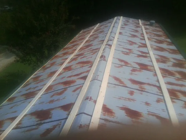 Rusted metal roof panels with new wood purlins before replacement — Storm Damage Roof Repair in Beltrami by Roofing Brothers