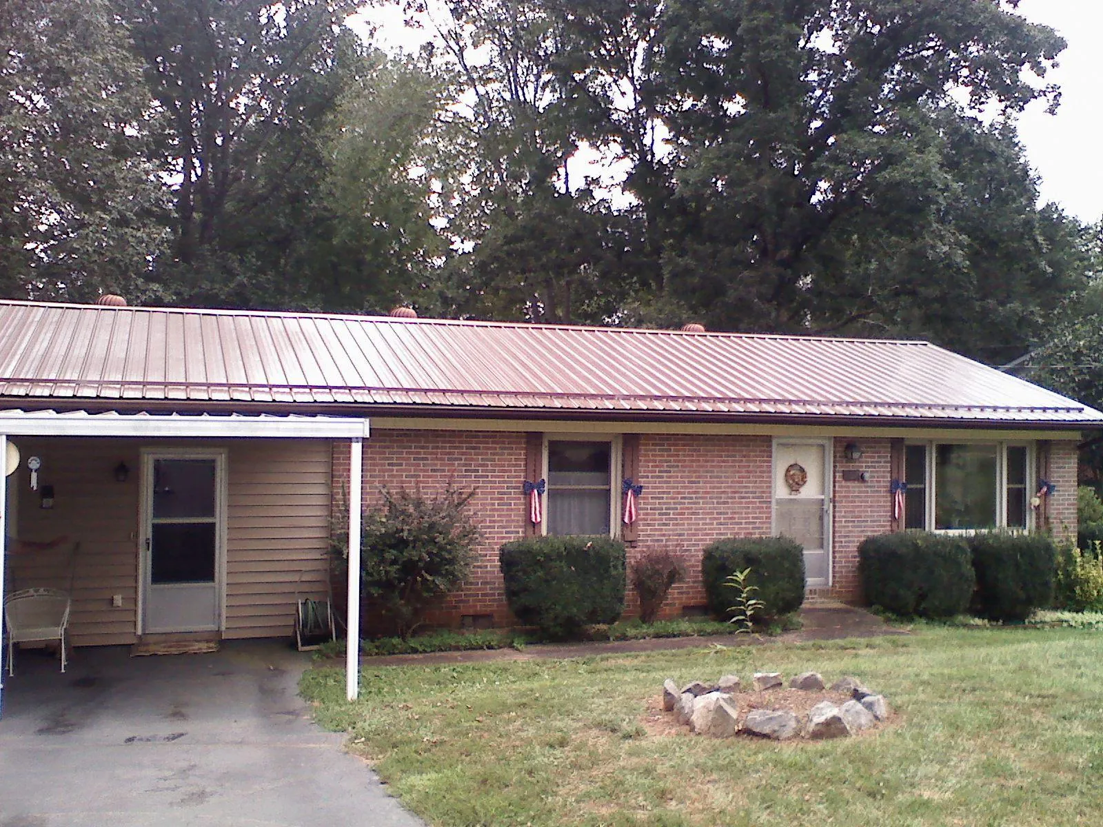 Bronze metal roof and carport on a brick ranch home — Roof Repair work by our crew in Beltrami